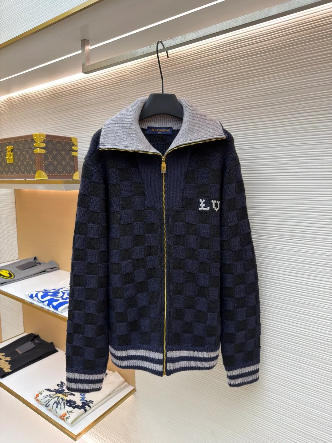 LOUIS VUITTON knitted waist contrast ribbed collar sweater ●Original version: Purchased and developed by 20433 ●Item number: 1682136-C15 ●Fabric: wool blended fabric ●Technology: knitted ●Color: black and blue ●Version: fitted version ●Weight: about 1360 grams ●Size: S-M-L-XL ●Description: This Louis Vuitton checkerboard knitted zipper jacket is made of double-ply merino wool blended yarn and is woven with a 12-needle three-dimensional knitting process on a German Stoll computerized flat knitting machine. The Damier checkerboard pattern on the body uses intarsia knitting techniques, and the layered interweaving of dark blue and black yarns creates a 3D concave and convex texture. There is no printed patchwork process, and the pattern and the body are integrated for a more textured look. The neckline is designed with contrasting ribbed lapels, and built-in spandex elastic yarn improves resilience; the metal zipper is made of gold-plated brass, and the teeth are precision polished. The zipper track and the seam of the body are sewn with overlock stitching, and the stitch length is controlled within 0.2cm. The contrasting ribbed edges on the cuffs and hem are pre-shrunk and hand-shaped and ironed, making the garment crisp and less likely to loosen after long-wearing. Every detail demonstrates the brand's strict standards of high-end knitting technology. The overall wiring is straight and delicate, the fabric is comfortable and soft, and the color is consistent without color difference. It can be matched with the same style to create a fashionable look and control various occasions. Customized accessories, complete with three standards, same style for men and women!